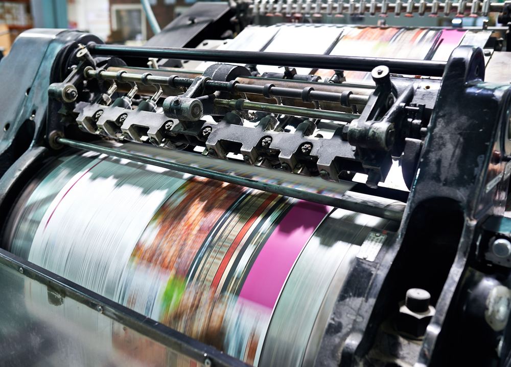 An industrial printing press producing colourful printed material